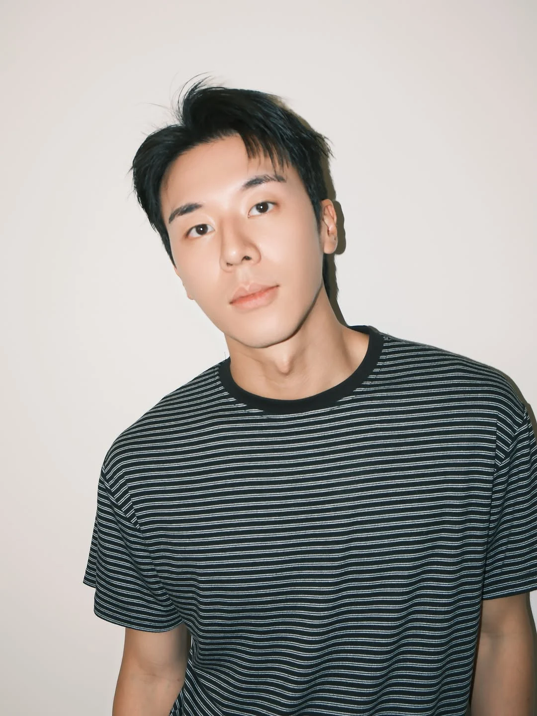 林嘉威穿深色细条纹上衣，在浅色背景前正面看向镜头；本人公开原帖照片